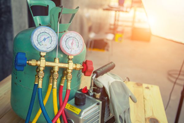 HVAC technician checking AC refrigerant levels